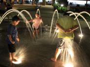 children playing in water fountain