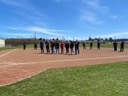group of people standing on a baseball field